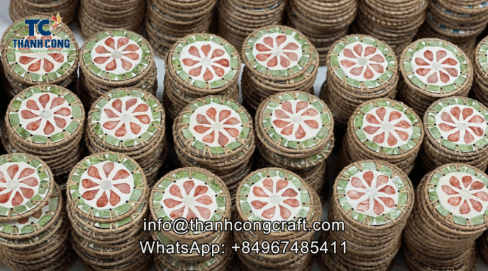 Person painting custom floral patterns on round wood coasters using fine brushes