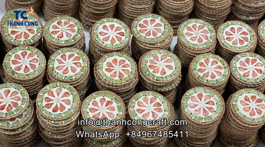 Person painting custom floral patterns on round wood coasters using fine brushes